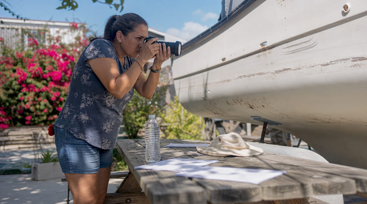 Person photographing boat HIN for registry search