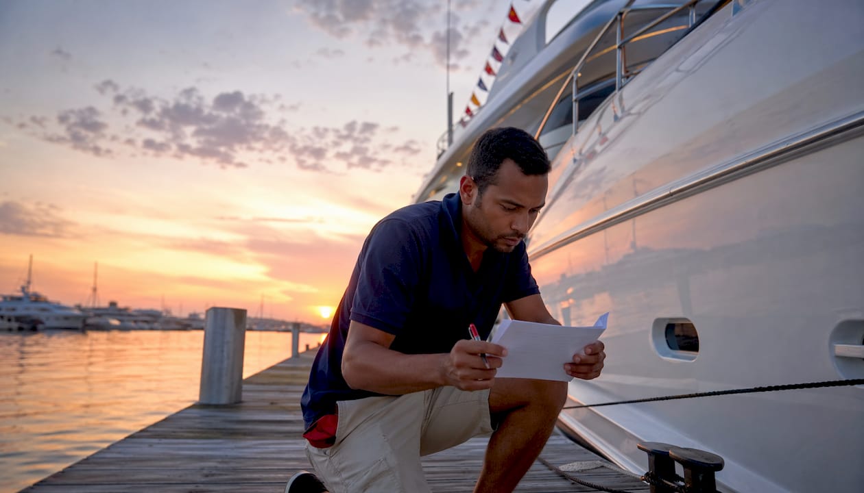Crew member reviewing yacht safety checklist outdoors