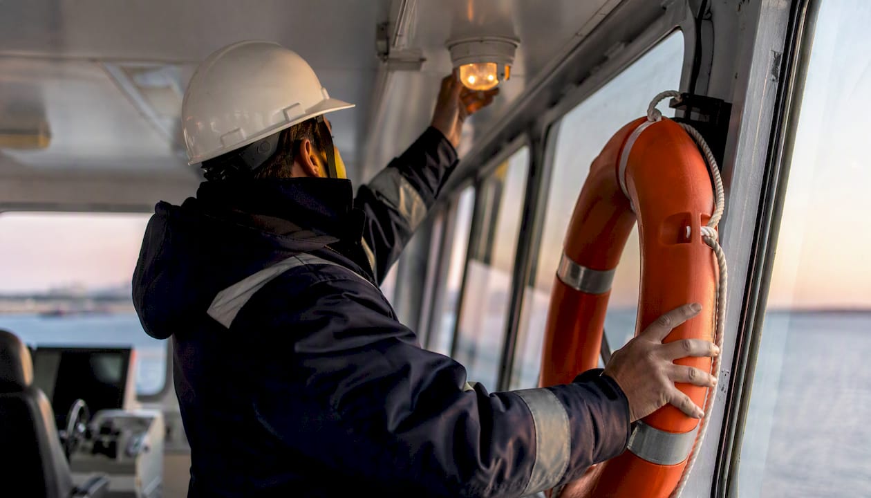 Ship security officer inspecting security equipment on deck