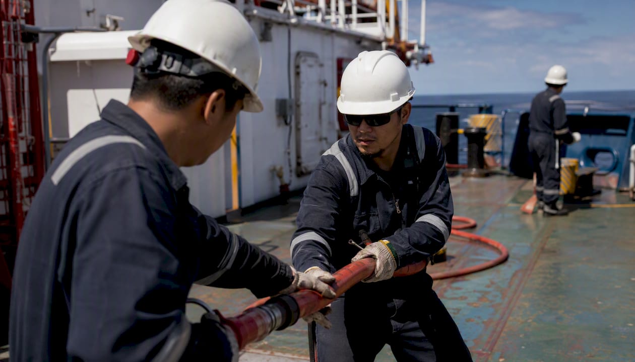 Hands operating fire extinguishers during ship drill