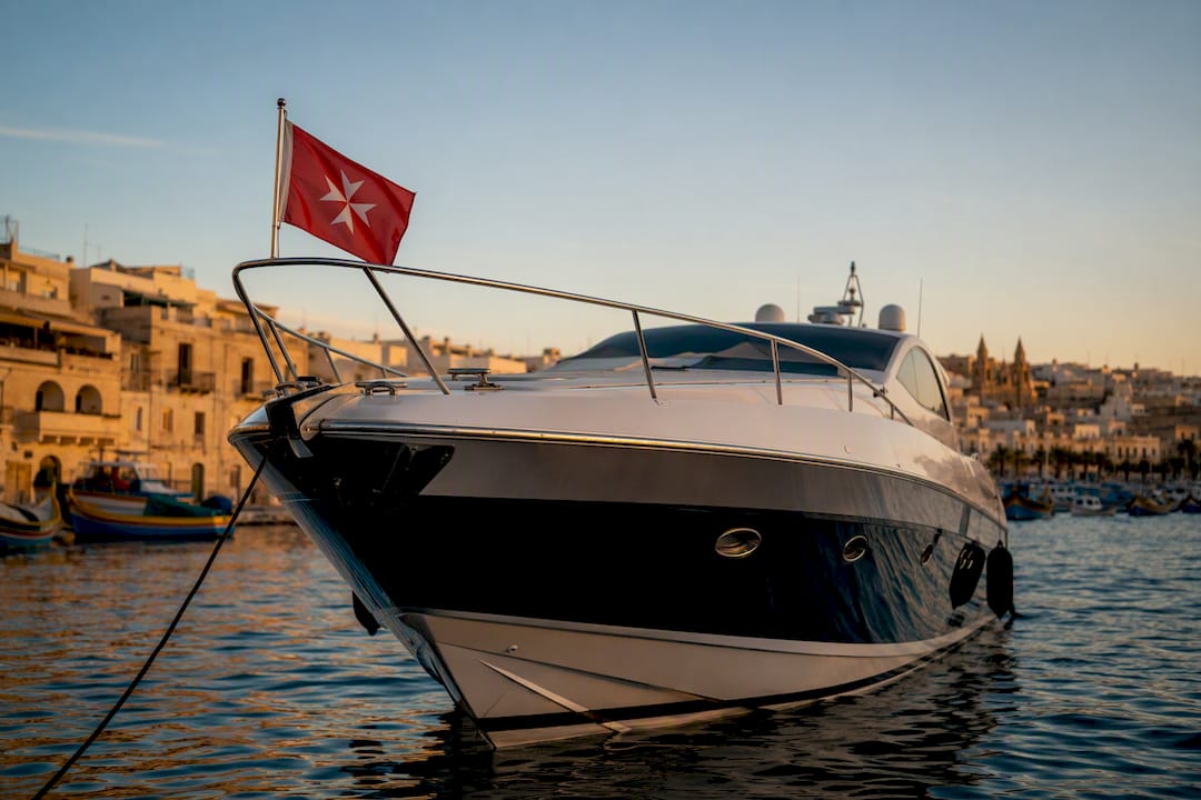Yacht moored in Maltese harbor with flag