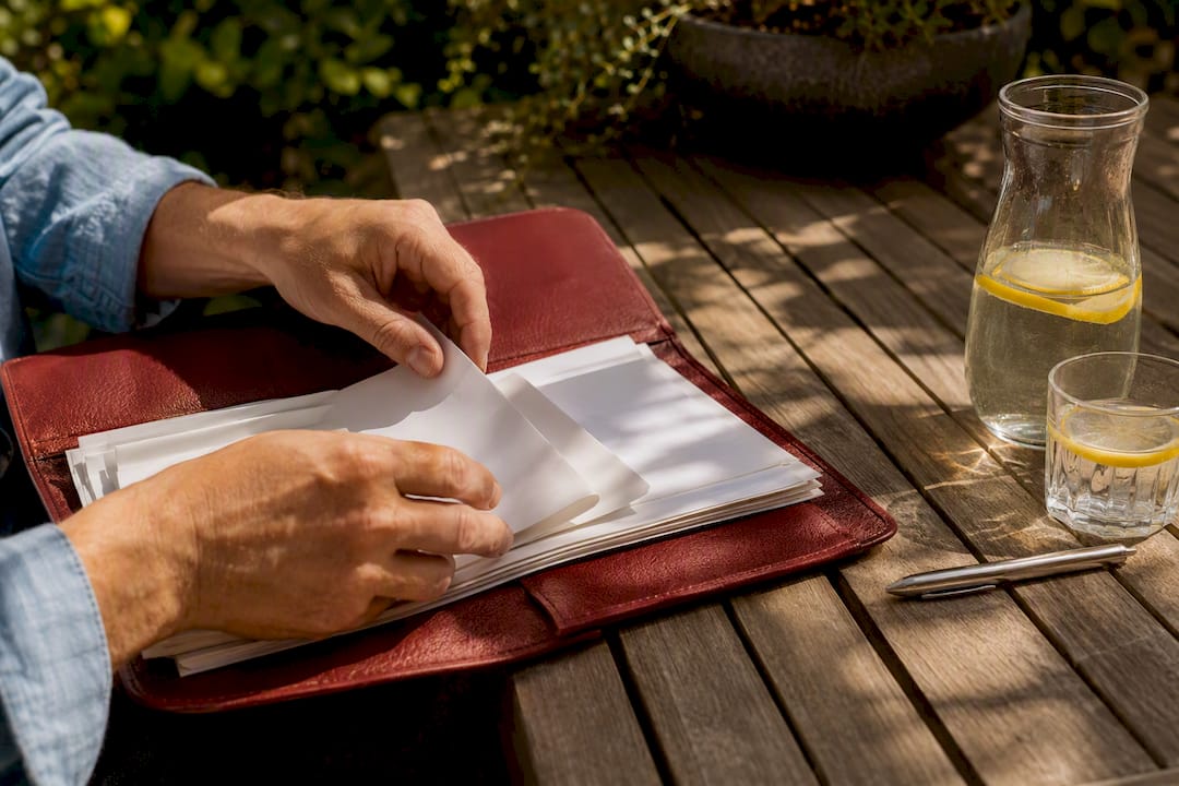 Hands organizing vessel ownership documents on table
