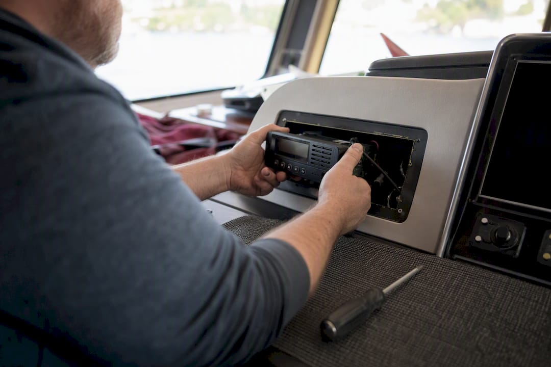 Hands installing marine communication device