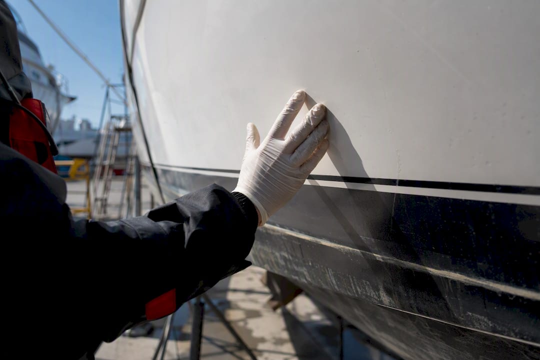 Surveyor inspecting yacht hull at dry dock
