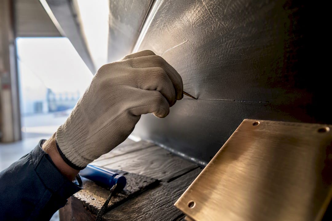 Surveyor inspecting carved vessel identification marking