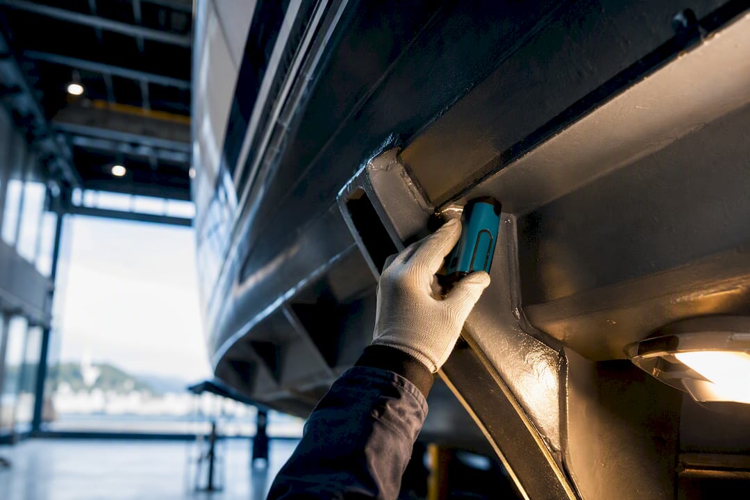 Surveyor examining yacht hull structure