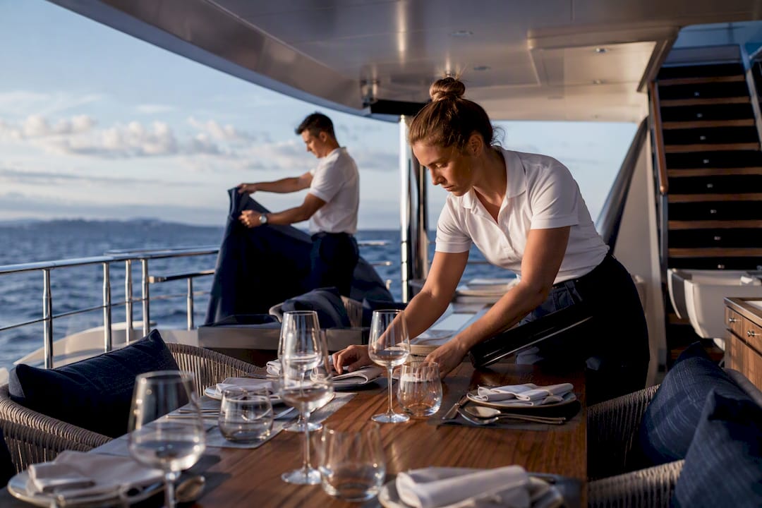 Yacht crew preparing guest service on deck