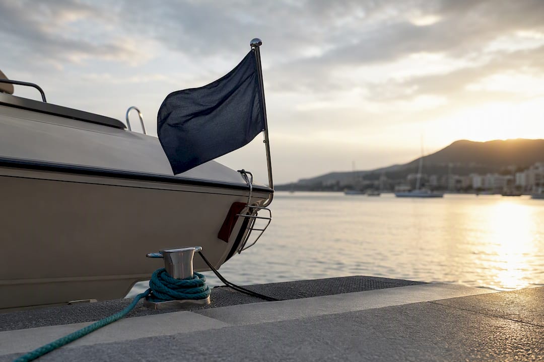 Moored yacht stern with maritime registration flag