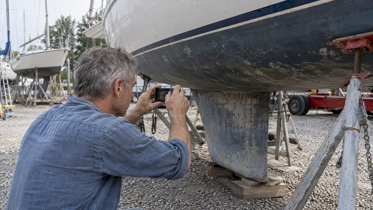 Owner documenting yacht hull before loading