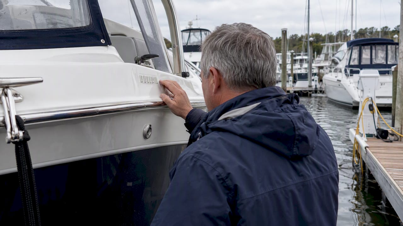 Owner inspecting a boat’s transom HIN marking
